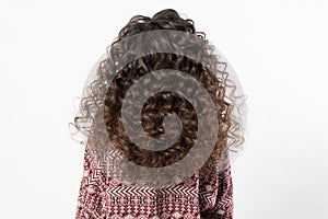 A woman with curly long dark hair, turned her back