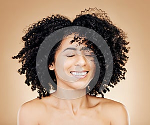 Woman, curly or wind in afro hair for fun on studio background in healthy hairstyle growth, texture or frizz treatment