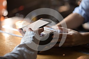 Woman customer holding phone near nfc terminal make mobile payment