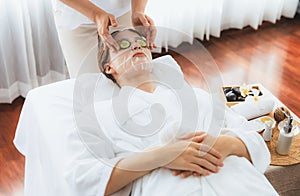 Woman customer indulges in rejuvenating with cucumber facial care. Quiescent