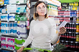 Woman customer looking at notes in shopping list