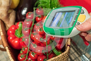 Woman customer using scanner device in supermarket. Automatic object recognition.