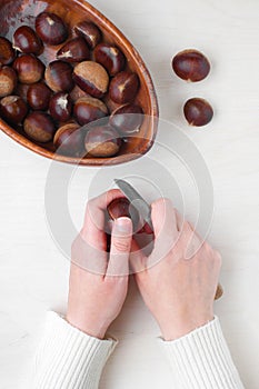 Woman cut the raw chestnut