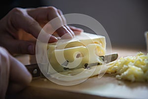 Woman cut slice cheese for cook using knife in the kitchen