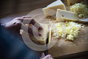 Woman cut slice cheese for cook using knife in the kitchen