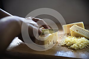Woman cut slice cheese for cook using knife in the kitchen