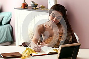 Woman with cute cat resting at home on autumn day