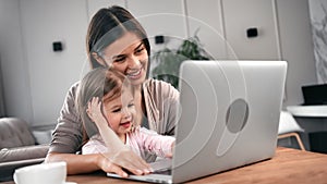 Woman and cute daughter studying computer or surfing internet. Medium close up shot on 4k RED camera