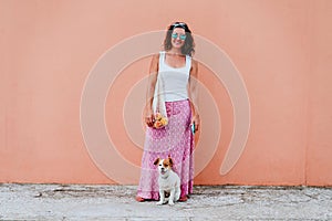Woman cute dog woman walking by the city, holding a cotton bag with fruit. Eco friendly, zero waste concept