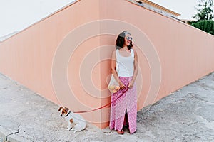 Woman cute dog woman walking by the city, holding a cotton bag with fruit. Eco friendly, zero waste concept