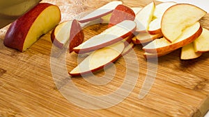 Woman cuts apples on a wooden cutting board.