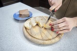 Woman cuts bread in the kitchen