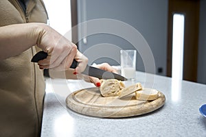 Woman cuts bread in the kitchen