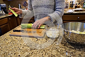 Woman cuts celery on cutting board