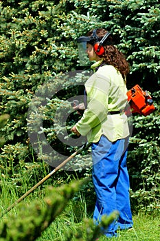 Woman cuts the grass.