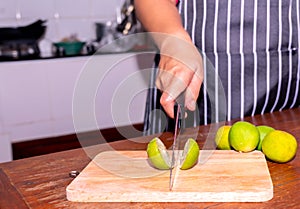 A woman cuts a lemon to cook dinner