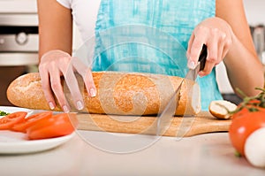 Woman cutting bread on the kitchen