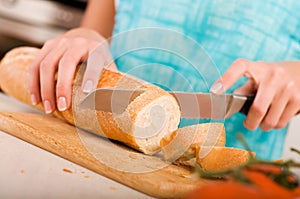 Woman cutting bread on the kitchen