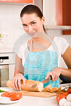 Woman cutting bread on the kitchen