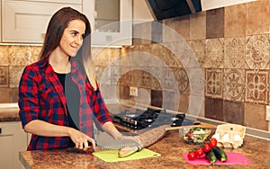 Woman cutting bread, preparing breakfast in kitchen