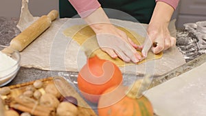 Woman cutting cookies from handmade dough with pastry cutter pumpkin biscuits