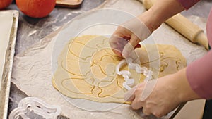 woman cutting cookies from handmade dough with pastry cutter pumpkin biscuits baking home kitchen autumn seasonal