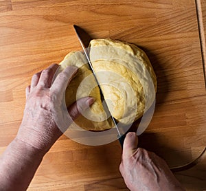 Woman cutting dough into pieces for further rolling