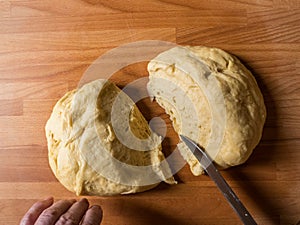 Woman cutting dough into pieces for further rolling