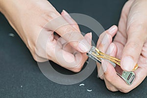 Woman cutting fingernails with nail scissors