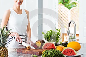 Woman cutting fruit in kitchen