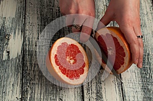 woman cutting grapefruits on a wooden board, studio shot