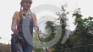 Woman cutting grass with corded electric lawn mower