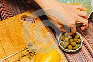 Woman cutting green olives for cooking