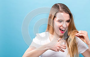 Woman cutting her hair with scissors
