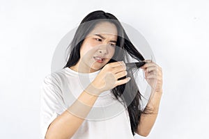 A woman is cutting her hair with scissors