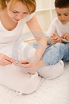 Woman cutting little boys toe nail