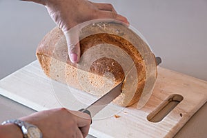 Woman cutting a loaf of white bread