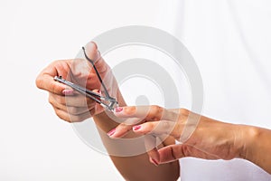 Woman cutting nails on finger using a nail clipper