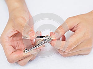 Woman cutting nails using nail clipper on white background. heal
