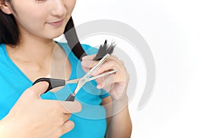 Woman cutting own hair with scissors