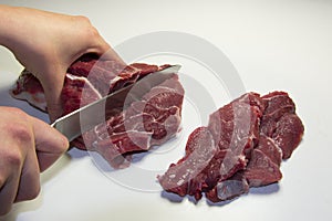 Woman cutting raw equino meat