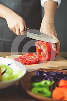 Woman cutting red bell peppers. Cooking vegan food. healthy with