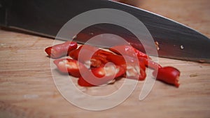 Woman cutting red chili with knife