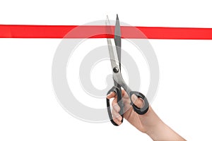 Woman cutting red ribbon with scissors on white background