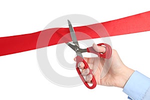 Woman cutting red ribbon on white background, closeup