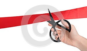 Woman cutting red ribbon on white background, closeup