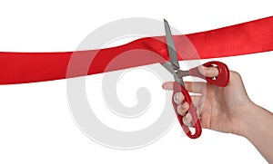 Woman cutting red ribbon on white background, closeup