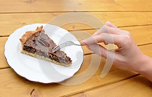 Woman cutting into a slice of pecan pie