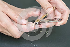 Woman cutting toenail with nail scissors