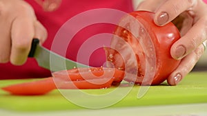 Woman cutting a tomato.